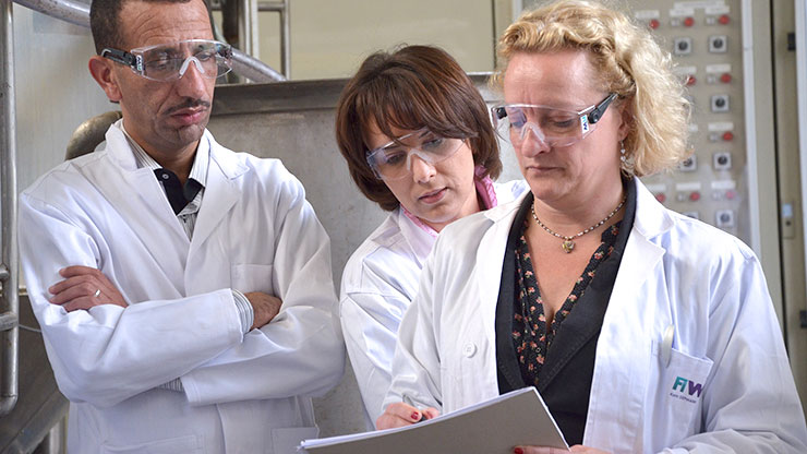 three people in white coats study together in one document