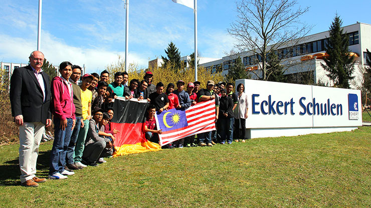 Group of international students holding flags in front of the Eckert Schulen