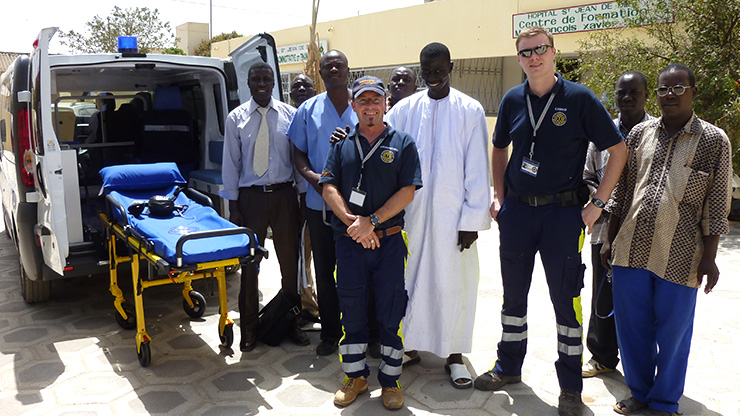 Group photo of trainers and trainees in front of ambulance in Dakar, Senegal