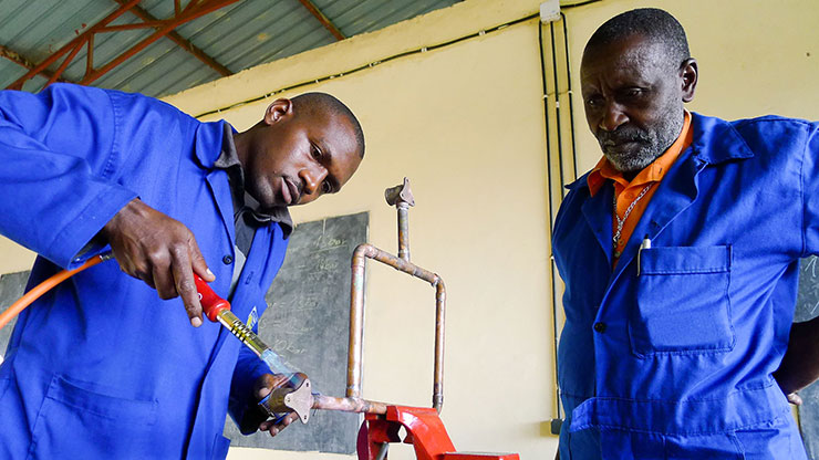 two men from Rwanda working in a training workshop
