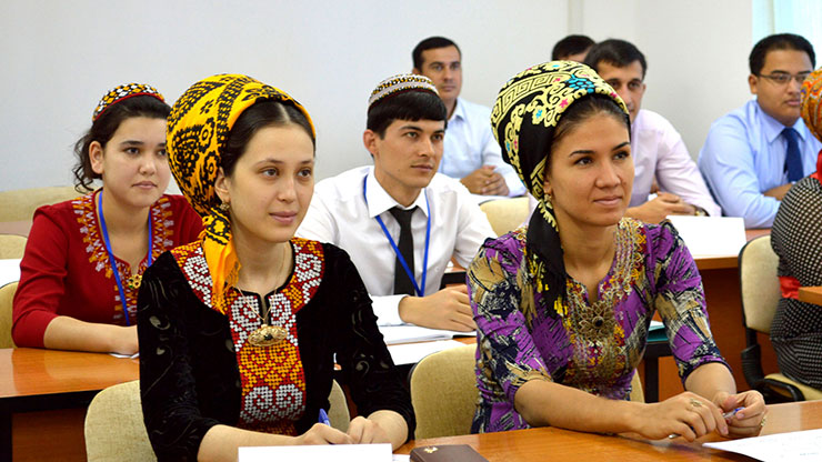 classroom with men and women from Turkmenistan in colourful traditional clothings